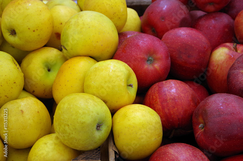 Yellow and red apples mixing in crates at market place