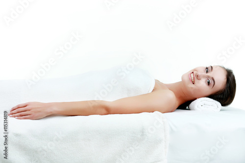 Beauty and spa concept - beautiful woman in spa salon lying on t