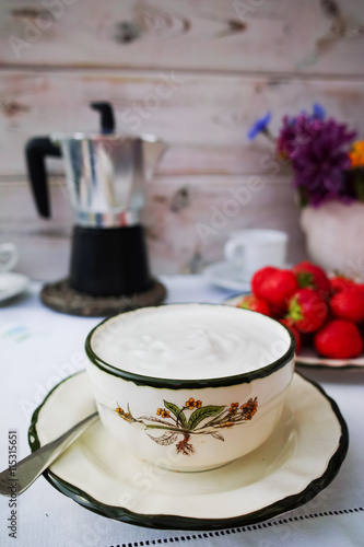 Breakfast served in a terrace - coffee, natural yogurt, strawber photo