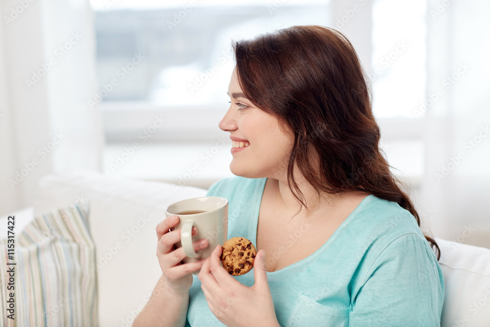 happy plus size woman with cup and cookie at home happy plus size woman with cup and cookie at home