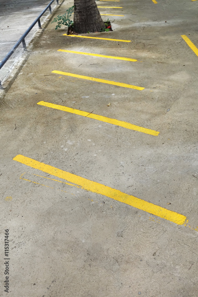 parking stalls in a parking lot, marked with yellow lines. parking stalls in a parking lot, marked with yellow lines.