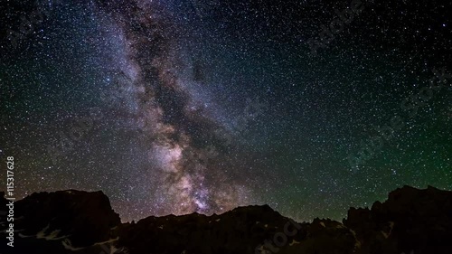 The outstanding beauty of the Milky Way and the starry sky beyond dramatic mountain ridge, captured at high altitude in summertime on the Italian Alps. Time Lapse 4k video.