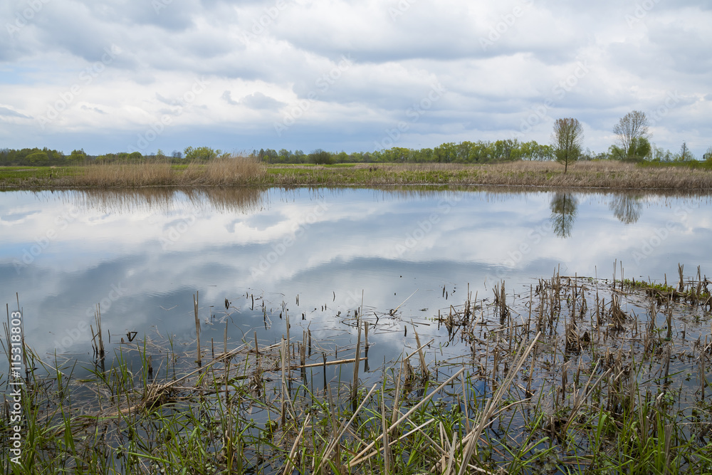 Quiet river, clouds reflected in the calm water depths. Spring. Quiet river, clouds reflected in the calm water depths. Spring.