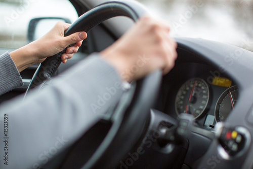 Driver's hands driving a car on a highway