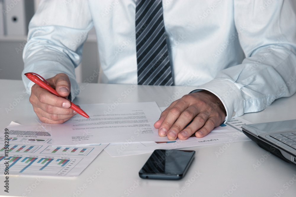 Business man sitting on the desk and working in office Business man sitting on the desk and working in office