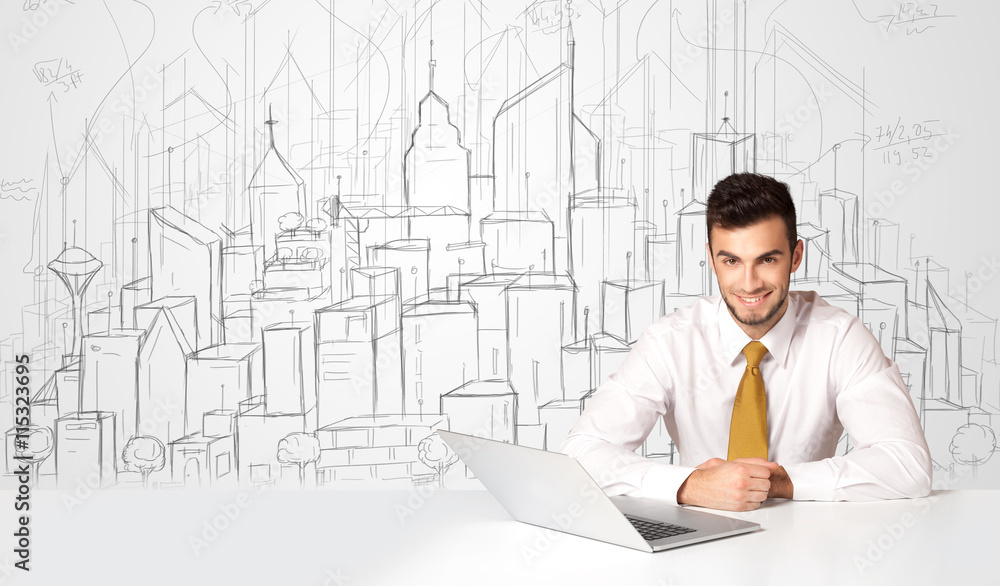 Businessman sitting at the white table with hand drawn buildings Businessman sitting at the white table with hand drawn buildings