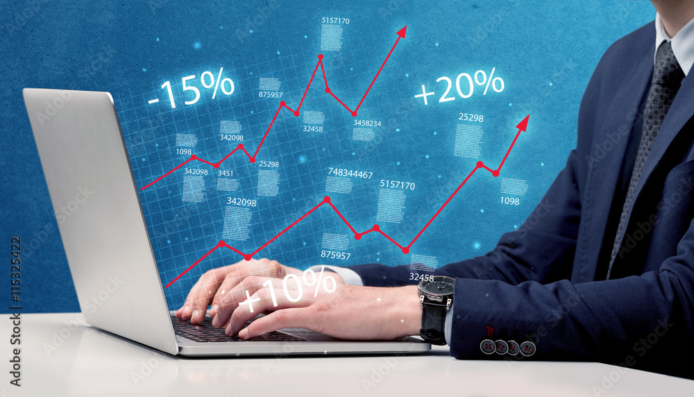 Salesman working on graph with laptop Salesman working on graph with laptop