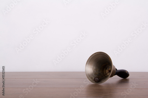 Old fashioned hand bell a wooden surface