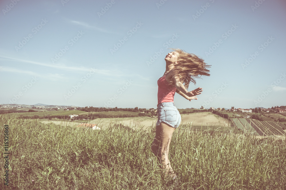 woman in a green field with open arms enjoys freedom woman in a green field with open arms enjoys freedom