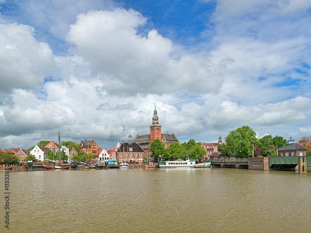 Leer, Germany. View from Leda river on City Hall in Dutch Renaissance style, Old Weigh House in Dutch classical Baroque style, Tourist Harbor with historical boats and Bridge of Erich vom Bruch.