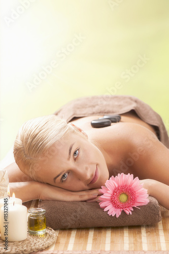 Blonde woman lying on a lounger having a massage