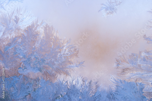 Fantastic abstract winter background  frost pattern on a window glass at the dawn   winter morning