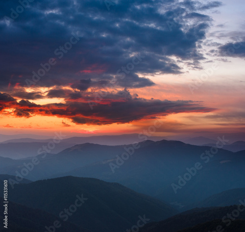 Beautiful panoramic sunset in the mountains landscape. Dramatic evening sky.