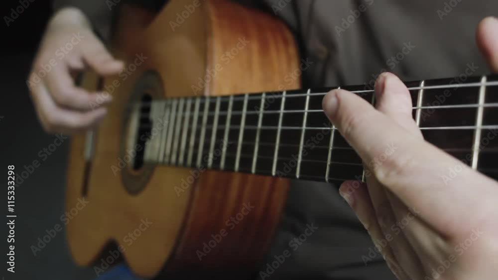 The man plays on a classical acoustic guitar The man plays on a classical acoustic guitar