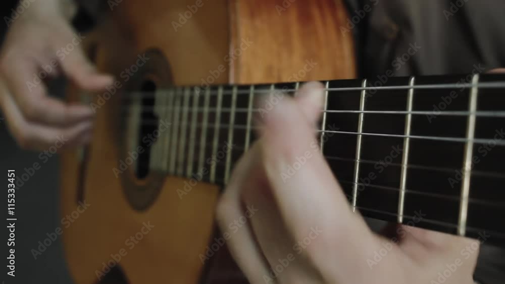 The man plays on a classical acoustic guitar The man plays on a classical acoustic guitar