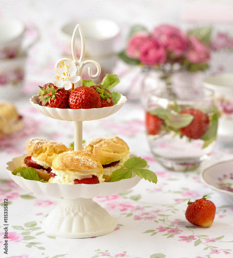 Cream puffs cakes or profiterole filled with whipped cream served with strawberries in plateau Cream puffs cakes or profiterole filled with whipped cream served with strawberries in plateau