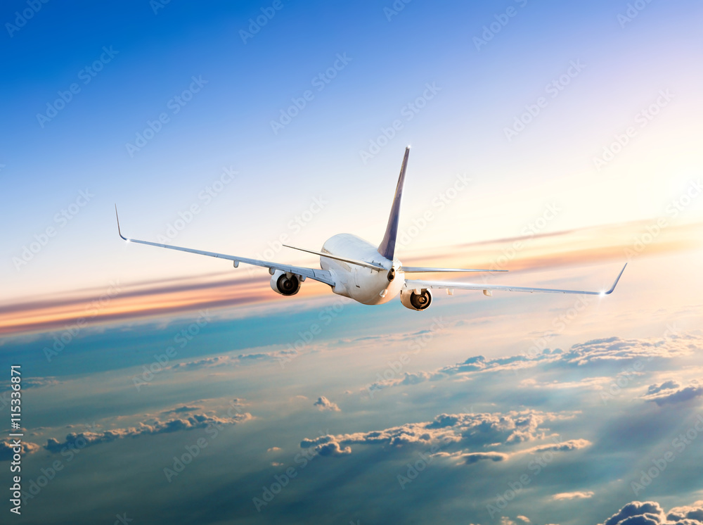 Naklejka premium Samolot latający nad chmury w dramatyczny zachód słońca