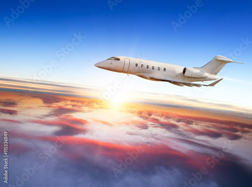 Private jet plane flying above clouds