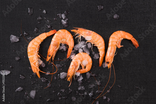 Shrimps on ice on black background.