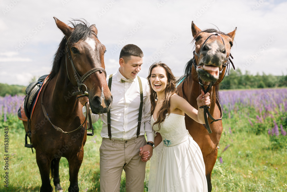 Obraz premium Happy wedding couple with horses