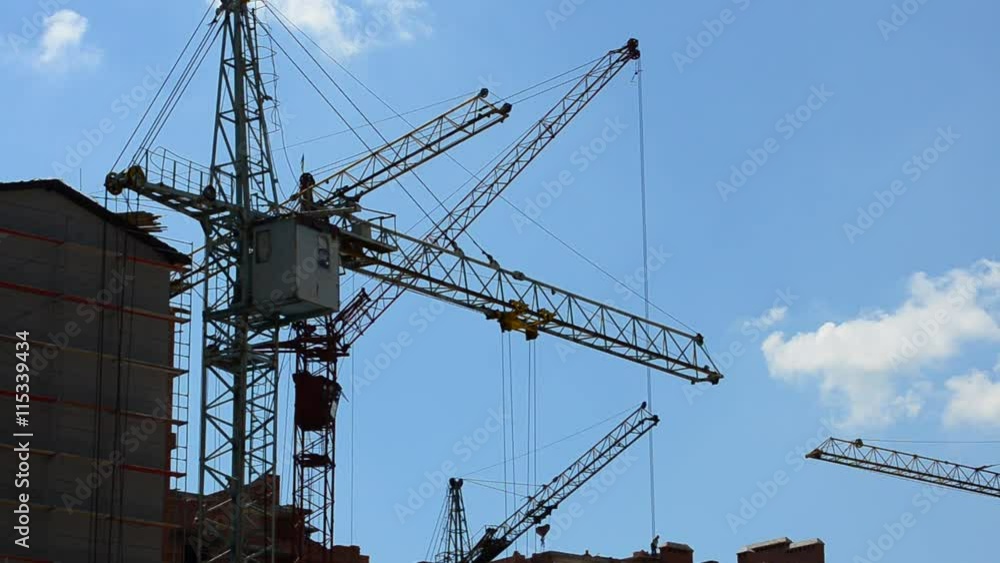 Construction cranes over houses. Construction cranes over houses.