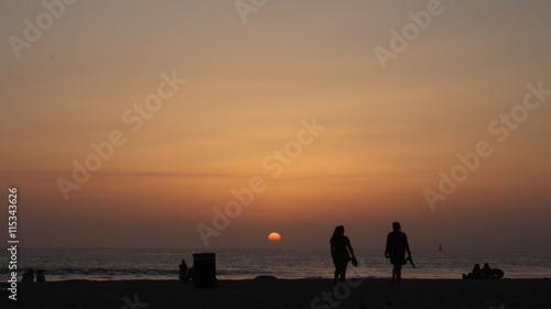 silhouette of people on the beach at sundown (ID: 115343626)