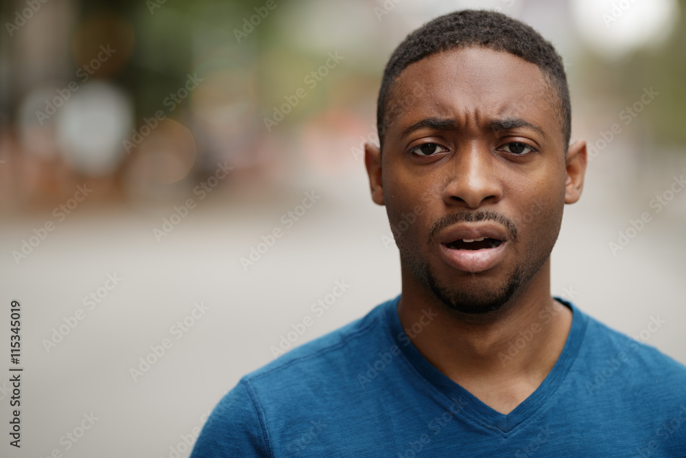 Fototapeta premium Young black man in city shocked face portrait