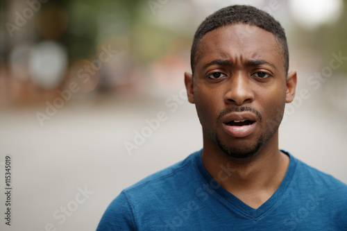 Young black man in city shocked face portrait