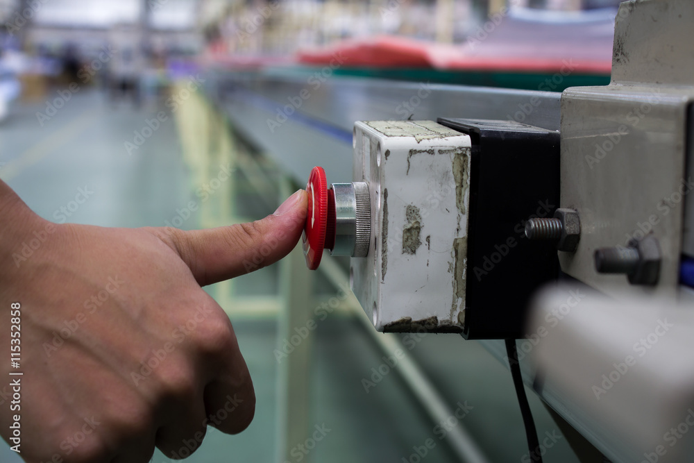 Male hand pushing emergency red stop button. Male hand pushing emergency red stop button.