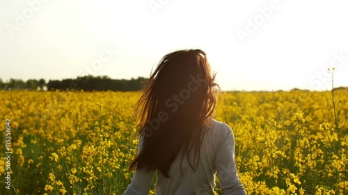 girl runs arms outstretched through a field slowmo