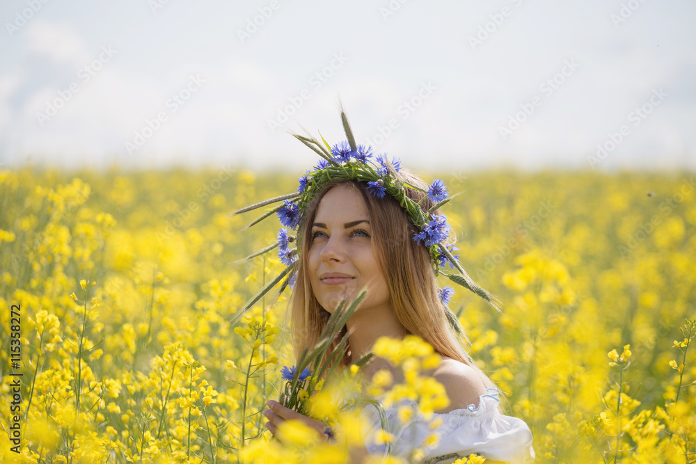 girl with a wreath of colorful flowers on her head, in a flowering yellow field girl with a wreath of colorful flowers on her head, in a flowering yellow field