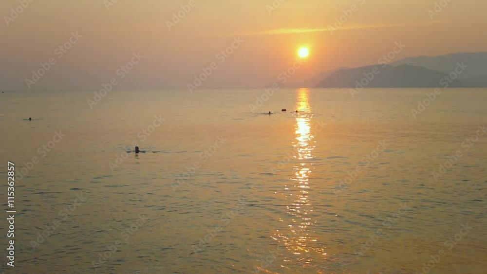 People Swim in the Sea at Sunrise. People Swim in the Sea at Sunrise.