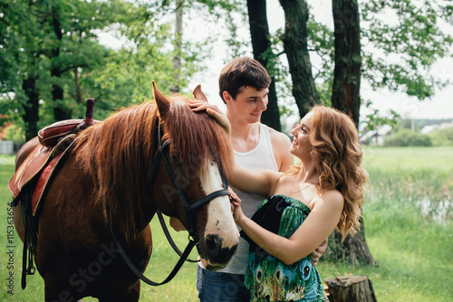 Lovers kissing and hugging on the background of horses