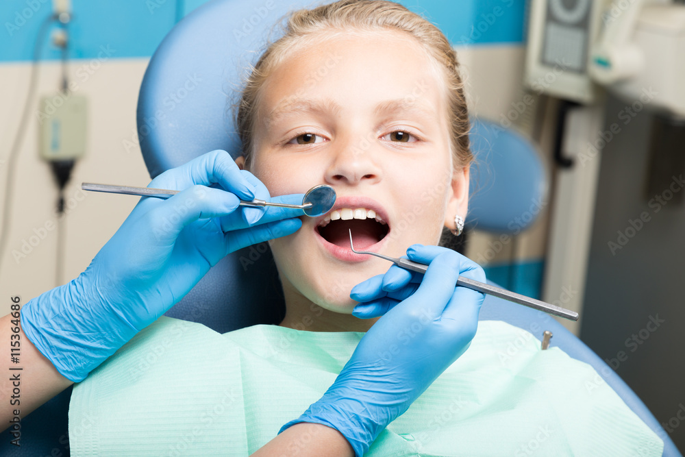 happy little girl with open mouth undergoing dental treatment at clinic. Dentist checked and curing teeth a child patient in the dental office happy little girl with open mouth undergoing dental treatment at clinic. Dentist checked and curing teeth a child patient in the dental office
