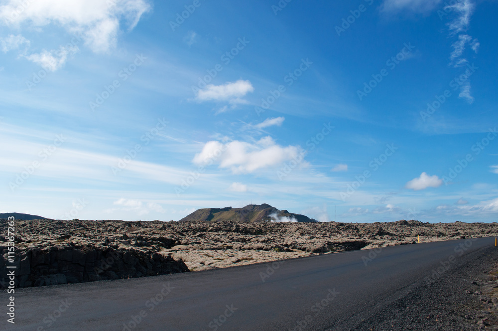 Islanda: una strada e il paesaggio islandese con campi di lava nella Penisola di Reykjanes il 16 agosto. In Islanda ci sono molti campi di lava di rocce nere coperte da un tappeto di muschio  