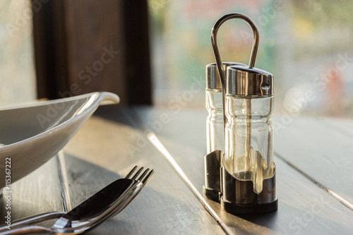 Assortment of spices in glass bottles on wooden background