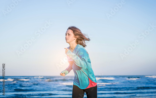 Young and caucasian woman runs alone on the beach - lifestyle  sports and outdoor concept