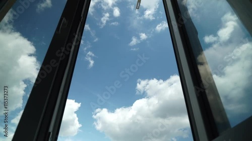 Flight of the Camera Through an Open Window into the Blue Sky With Clouds