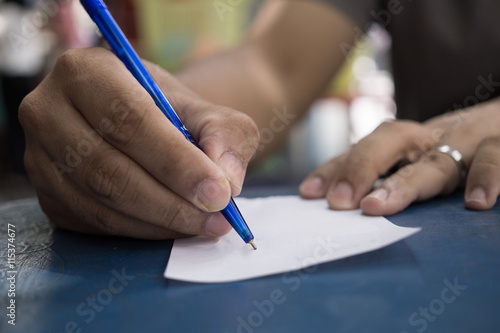 man's hand writing on paper