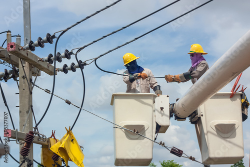 electrical utility worker in a bucket fixes a problem with a pow