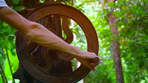 Old, hand crank powered, mechanical latex press at a rural processing operation in Southeast Asia. Video FullHD photo