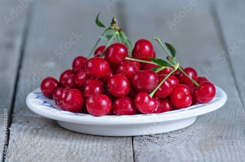 Cherry in dish, on the old boards