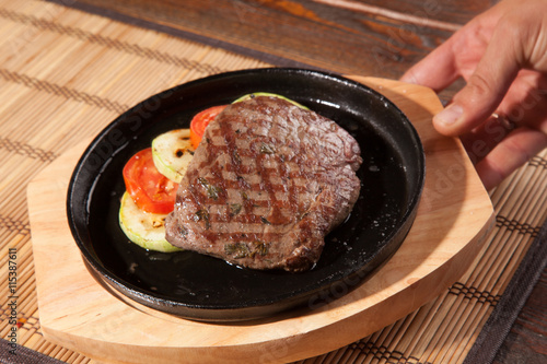 Steak flambe on black pan