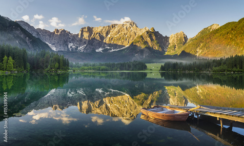 łódki zacumowane przy drewnianym pomoście nad pięknym,górskim jeziorem
