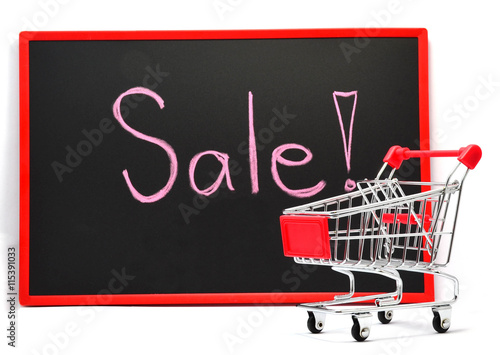 Shopping cart with chalk written word "Sale" on black board