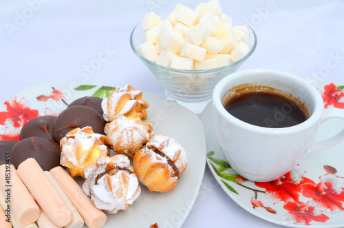 Сладости к кофе - печенье  со сгущенкой присыпанное пудрой сахар кубиками и чашка кофе