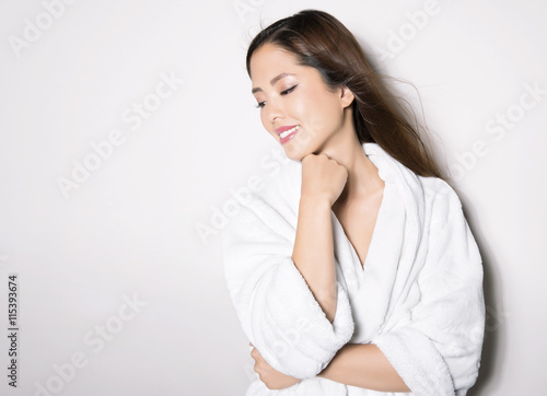 beautiful young asian woman with flawless skin and long hair posing in bath robe