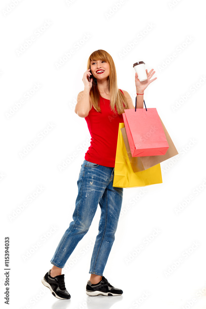 Young beautiful girl standing with purchases over white background.