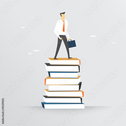 Businessman standing on book stack 
