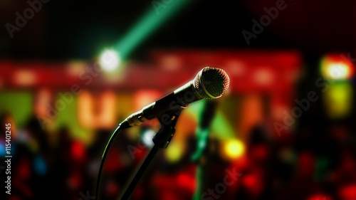 Microphone on stage ready for performer with full audience blurred background